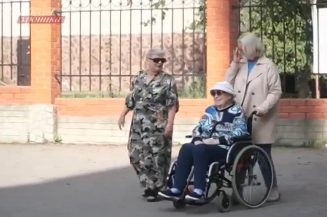 Ольга Шукшина помогает маме и везет коляску, а рядом идет сиделка Елена. Кадр «Пятый канал»